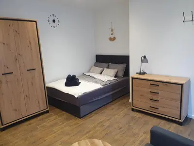 a bedroom with a bed and a dresser with a mirror at Urban Oasis Studios in Kaunas