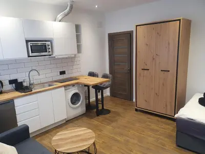 a small kitchen with a table and a microwave at Urban Oasis Studios in Kaunas