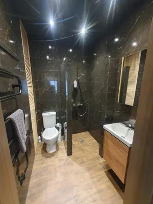 a bathroom with a toilet and a shower and a sink at Urban Oasis Studios in Kaunas