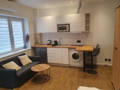 a living room with a couch and a kitchen at Urban Oasis Studios in Kaunas