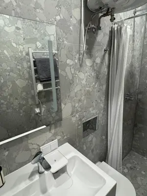 a bathroom with a sink and a mirror and a shower at 15 New Airport Apartment in Vilnius