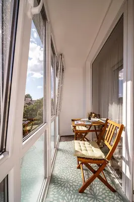 a balcony with a table and a chair on a balcony at Urban Oasis Apartments in Šiauliai