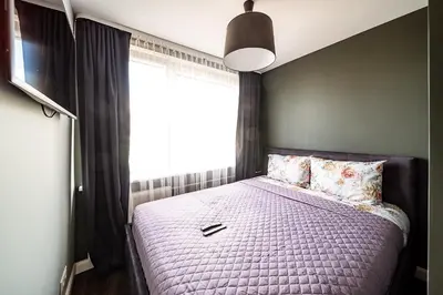 a bedroom with a bed with a large window at Urban Oasis Apartments in Šiauliai