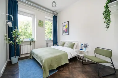 a white bedroom with a bed and a chair at Central Avenue Residence Kaunas in Kaunas