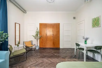 a room with a table and chairs and a wooden door at Central Avenue Residence Kaunas in Kaunas