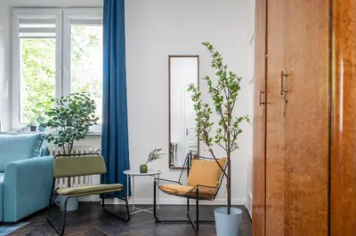 a living room with a blue couch and chairs at Central Avenue Residence Kaunas in Kaunas