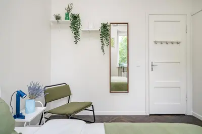 a white room with a chair and a mirror at Central Avenue Residence Kaunas in Kaunas