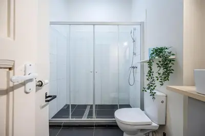 a bathroom with a shower with a toilet and a plant at Central Avenue Residence Kaunas in Kaunas