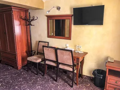 a room with a table and a desk and a television at Pas Radvila in Kaišiadorys