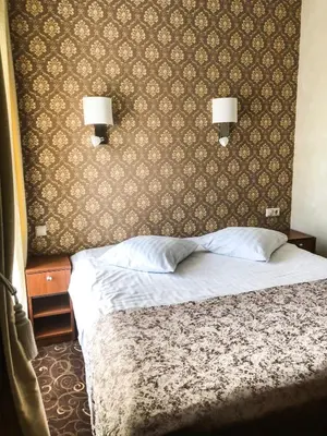 a bedroom with a bed with two lamps on the wall at Pas Radvila in Kaišiadorys