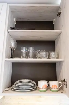 a cupboard with plates and bowls and dishes at Park's Edge apartment in Kaunas