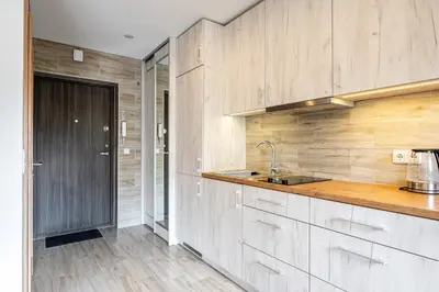 a kitchen with wooden cabinets and a sink at Park's Edge apartment in Kaunas