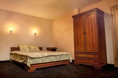 a bedroom with a bed and a wooden cabinet at Kambarių nuoma Žasliuose in Žasliai