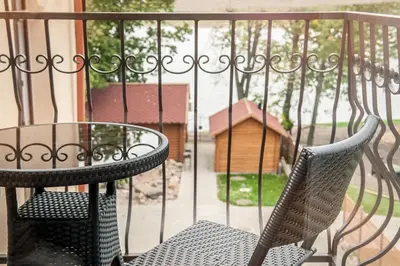 a table and chairs on a balcony with a fence at Kambarių nuoma Žasliuose in Žasliai