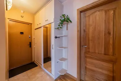 a hallway with a door and shelves next to a room at Monic Apartments in Šiauliai