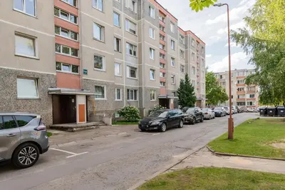 a row of parked cars parked in front of buildings at Monic Apartments in Šiauliai