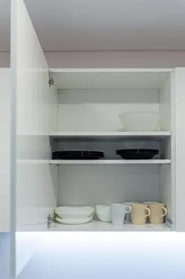 a white cabinet filled with bowls and plates at Pailsėk Rasytės oazėje, Kaune in Kaunas