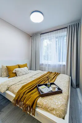 a bedroom with a large bed with a tray on it at Pailsėk Rasytės oazėje, Kaune in Kaunas