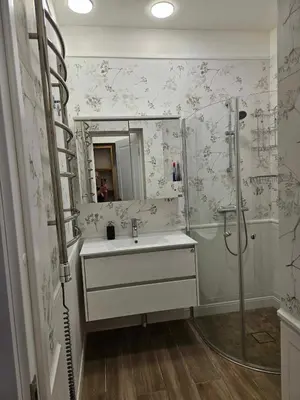 a bathroom with a sink and a shower and a mirror at Suncity apartamentai in Šiauliai