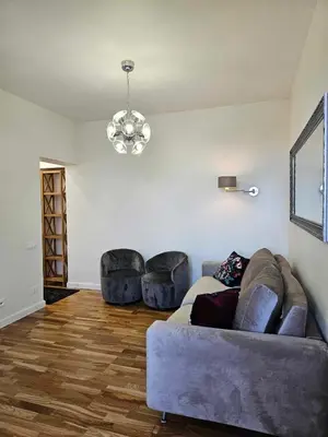 a living room with a couch and two chairs at Suncity apartamentai in Šiauliai