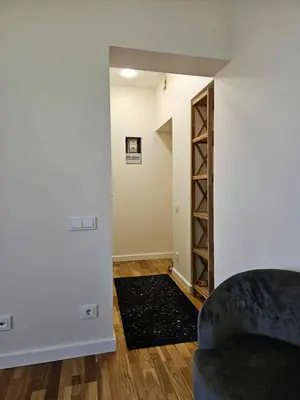 a living room with a couch and a book shelf at Suncity apartamentai in Šiauliai