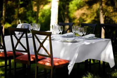 a white table with glasses and plates on it at Dzūkijos dvaras in Alytus