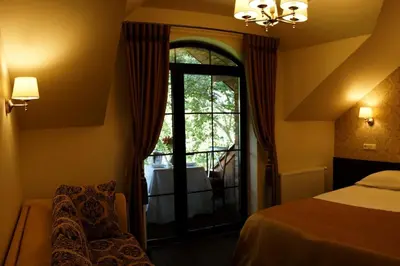 a bedroom with a bed and a window and a chair at Dzūkijos dvaras in Alytus