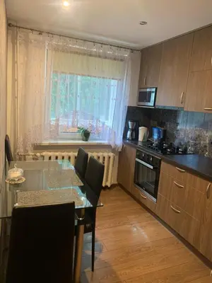 a kitchen with a table with chairs and a window at Vytauto 36a in Zarasai