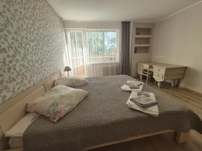 a bedroom with two beds and a desk and a window at Čiurlionis Apartment Druskininkai in Druskininkai