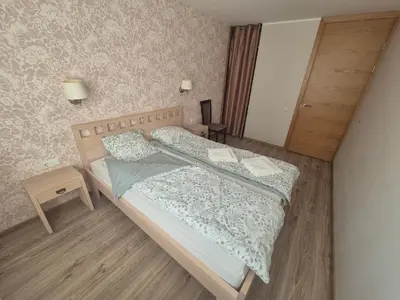 a small bedroom with two beds and a table at Čiurlionis Apartment Druskininkai in Druskininkai