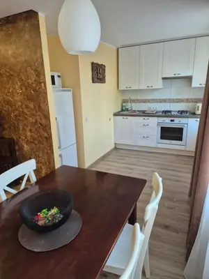 a kitchen with a wooden table with a bowl on it at Čiurlionis Apartment Druskininkai in Druskininkai