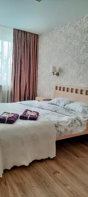 a bedroom with a large bed with purple pillows on it at Čiurlionis Apartment Druskininkai in Druskininkai