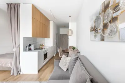 a small living room with a couch and a kitchen at Žalia kopa in City center in Vilnius