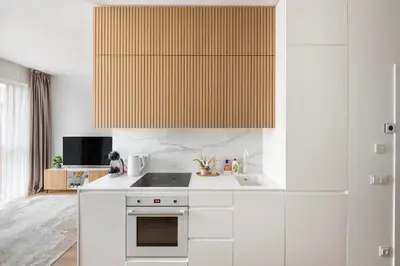 a kitchen with white cabinets and a stove top oven at Žalia kopa in City center in Vilnius