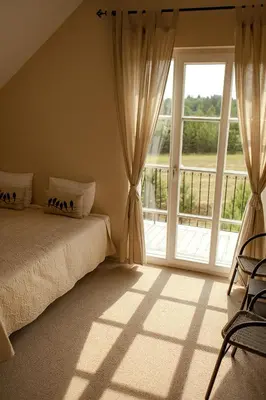 a bedroom with a bed and a large window at Provansalio dvaras in Babriškės