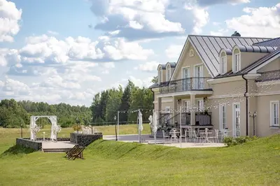 a large house with a patio and a lawn at Provansalio dvaras in Babriškės
