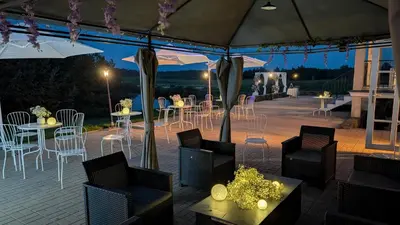 a patio with tables and chairs under a tent at Provansalio dvaras in Babriškės