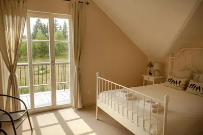 a bedroom with a bed and a large window at Provansalio dvaras in Babriškės