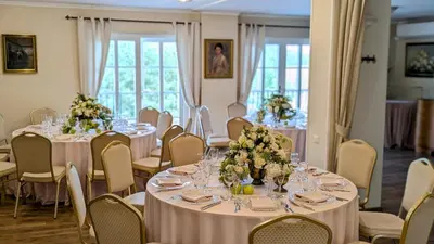 a room with tables and chairs with flowers on them at Provansalio dvaras in Babriškės