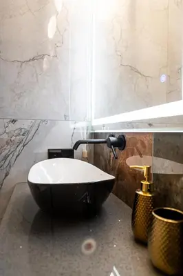 a bathroom with a black and white sink at AMJ Royal Apartments - 110 - Latte in Kaunas
