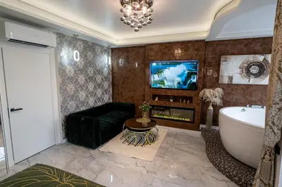 a bathroom with a tub and a couch and a tv at AMJ Royal Apartments - 110 - Latte in Kaunas