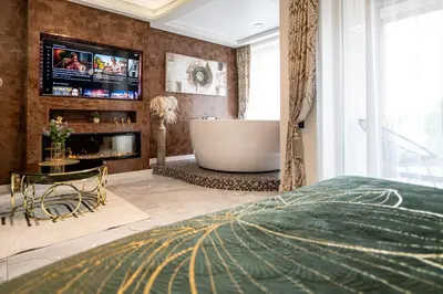 a master bedroom with a tub and a tv at AMJ Royal Apartments - 110 - Latte in Kaunas