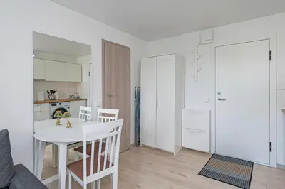 a kitchen and dining room with a white table and chairs at Partizanų studio apartment #2 by Polo Apartments in Kaunas