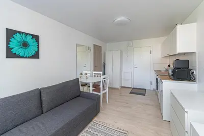 a living room with a couch and a kitchen at Partizanų studio apartment #2 by Polo Apartments in Kaunas