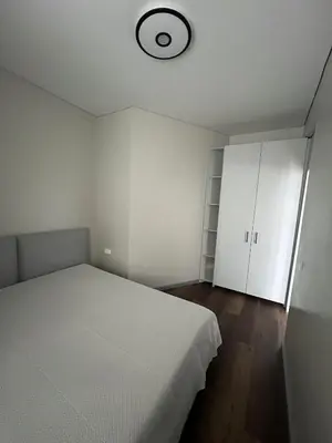 a bedroom with a white bed and a clock on the ceiling at Patrick in Šveicarija