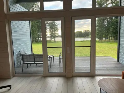 a screened in porch with a bench and a table at Zanapolio ranča in Norvaišiai