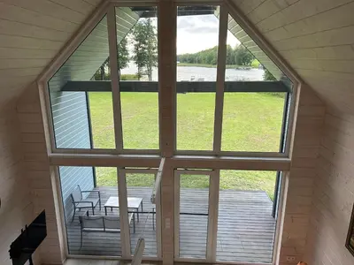 a view from the inside of a house with a large window at Zanapolio ranča in Norvaišiai