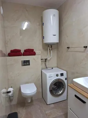a bathroom with a washing machine and a toilet at Rent Olamit in Karkazai