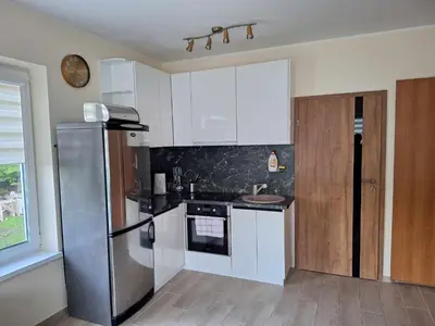 a kitchen with white cabinets and a stainless steel refrigerator at Rent Olamit in Karkazai