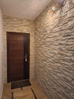a hallway with a stone wall next to a door at Rent Olamit in Karkazai